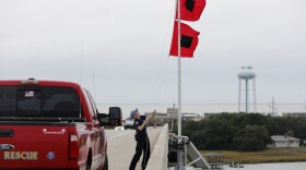 Chief Ann Graham, with the Isle of Palms Fire Department, raises two hurricane flags over the Isle of Palms Connector in preparation for Hurricane Matthew on Isle of Palms, S.C., October 6, 2016. 
