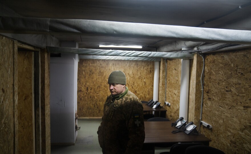 The bunker complex includes bedrooms, bathrooms, a kitchen and dining hall, office space, and a large central command room lined with desks and giant TV screens.