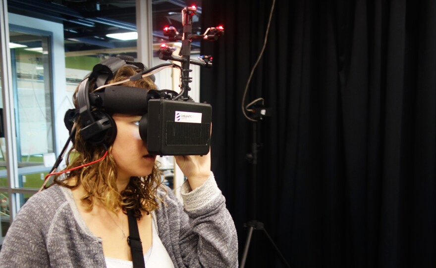 Allison Begalman, a student at the University of Southern California, wears goggles and headphones to experience a virtual mortar strike on civilians in Aleppo, Syria.