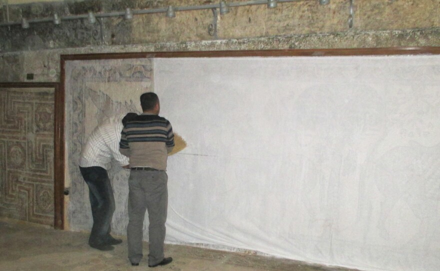 Syrian volunteers work to protect mosaics in the Ma'arra Museum.