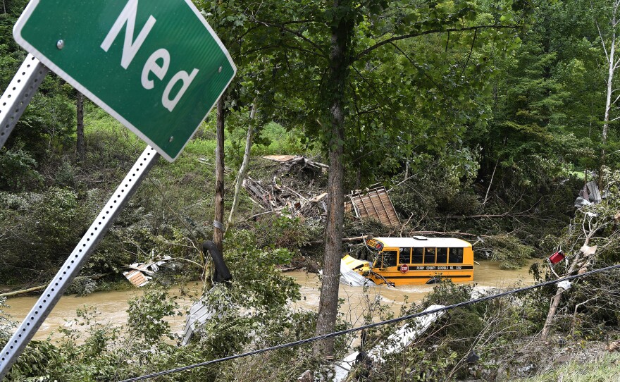 A Perry County school bus lies destroyed after being caught up in the floodwaters of Lost Creek in Ned, Ky., on Friday.