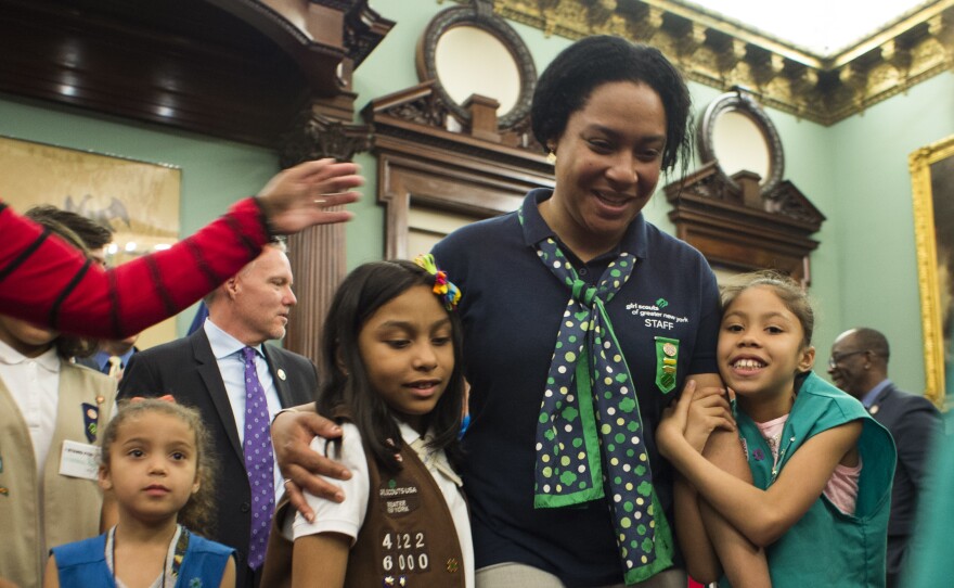 Members of Girl Scout Troop 6000 troop and leader Giselle Burgess hug after being honored as the first troop exclusively for homeless girls, at a ceremony at New York City Hall on April 25.