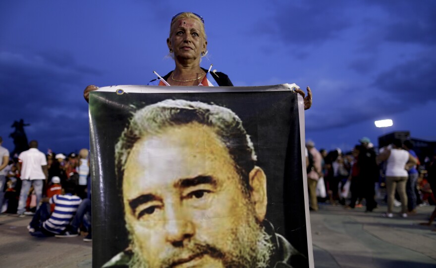 A woman holds a picture of Fidel Castro before a rally honoring Cuba's late leader at Antonio Maceo plaza in Santiago, Cuba.
