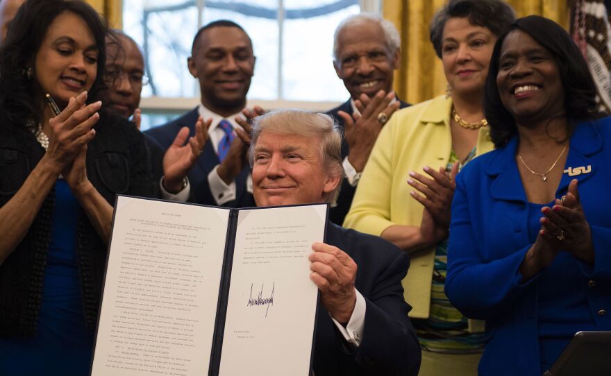 President Trump holds up an executive order to bolster HBCUs after signing it in the Oval Office on Tuesday.