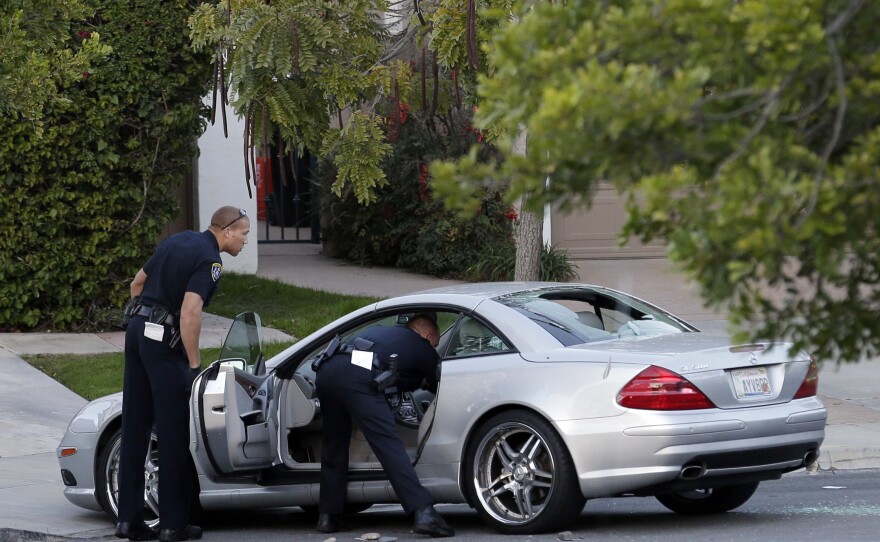 San Diego police examine the scene following the shooting of CBS News 8 sportscaster Kyle Kraska at his Scripps Ranch home, Feb. 10, 2015.
