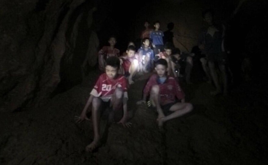 The boys and their soccer coach, seen in partially flooded cave in northern Thailand on Monday. Found after more than a week of searching, they are mostly in stable medical condition and have received high-protein liquid food, officials said Tuesday.
