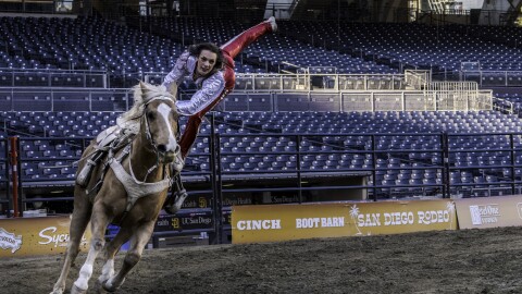A woman performs stunts on a running horse at San Diego Rodeo inside Petco Park, Jan. 15, 2026.