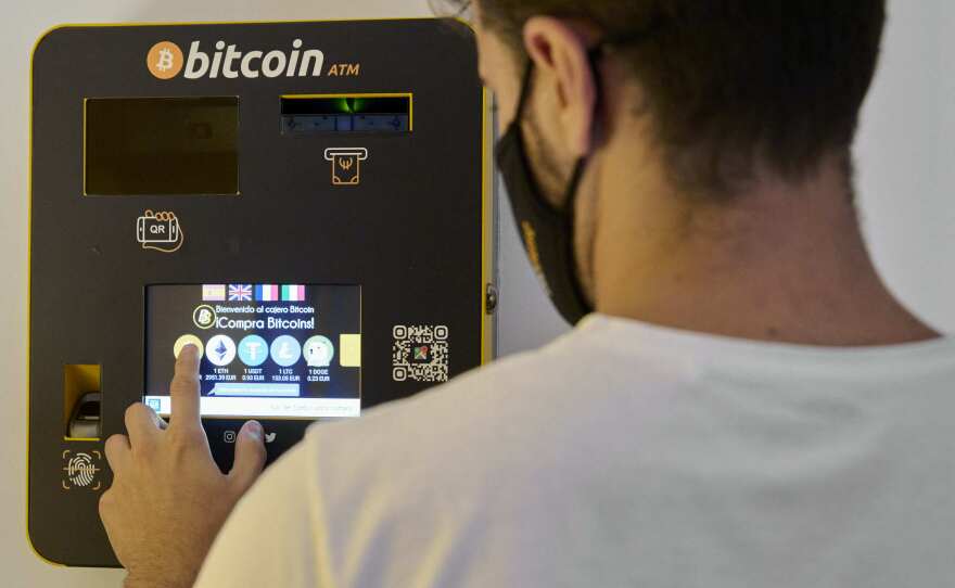 An employee demonstrates how the Bitcoin ATM works at the BitBase Store in Palma de Mallorca, Spain, on on August 9, 2021. Cryptocurrencies such as bitcoin are starting to become more popular.