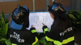 Two Joyner Elementary School students who work as fire fighters in the school's micro city review exit route maps.