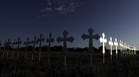 The sun is reflected on some of the 26 crosses placed in a field before a vigil for the victims of the First Baptist Church shooting Monday, Nov. 6, 2017. 