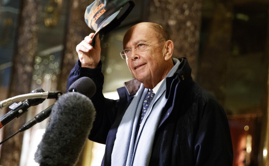 Wilbur Ross, the president-elect's choice for commerce secretary, tips a "Make America Great Again" cap in the lobby of Trump Tower on Tuesday.