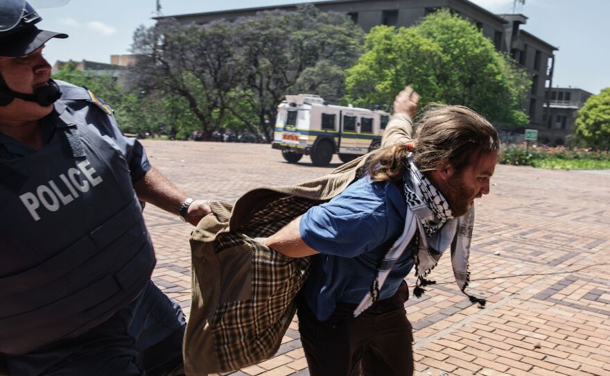 A South African policeman unsuccessfully tries to apprehend a student from the University of the Witswatersrand, also known as Wits University, on Monday. Student protesters at the prestigious university forced their way into lecture halls and caused many lessons to be abandoned, ratcheting up pressure in a battle over tuition fees.