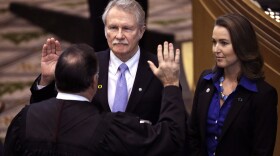 In this Jan. 12, 2015 file photo, Oregon Gov. John Kitzhaber, middle, is joined by his fiancee, Cylvia Hayes, as he is sworn in for an unprecedented fourth term by Senior Judge Paul J. De Muniz in Salem, Ore. 