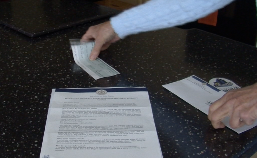 Kathy Casey's refund check and a letter from the city of San Diego informing property owners they've been overcharged.