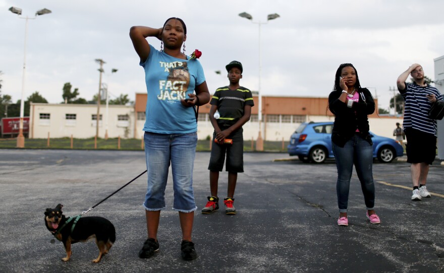 Demonstrators protesting the shooting death of Michael Brown listen as rapper, Nelly, speaks.