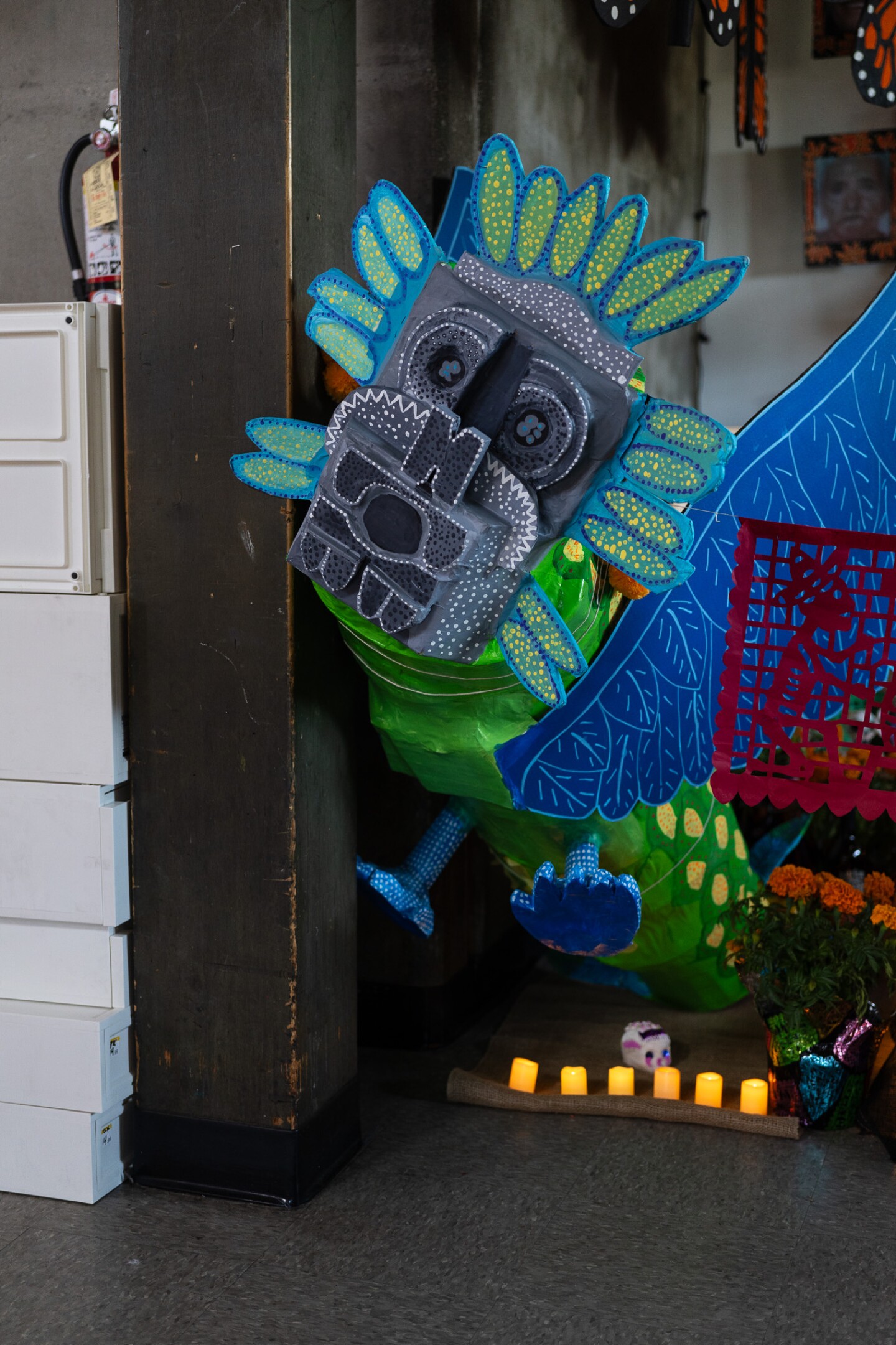 An alebrije, or Mexican folk art sculpture of a mystical spiritual creature, watches over one of the altars at the Sherman Heights Community Center in San Diego on Oct, 17, 2023.