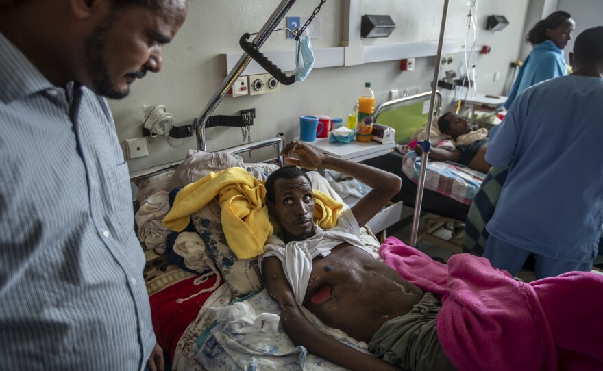 In a May 6, 2021 file photo, a farmer, Teklemariam Gebremichael, who said he was shot by Eritrean forces in Enticho six months before and is still recovering, speaks to a doctor, left, at the Ayder Referral Hospital in Mekele, in the Tigray region of northern Ethiopia. The United States on Monday imposed sanctions on Eritrea's chief of staff of the defense forces.