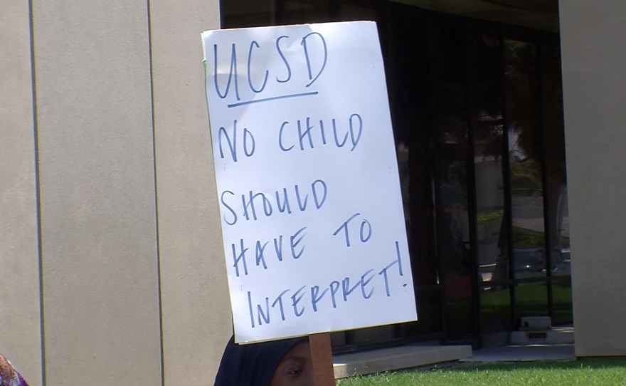 Protesters carried signs in both English and their native languages to tell hospital administrators they're tired of relying on their children to communicate with doctors. It is illegal for medical providers to ask children to interpret for their parents.