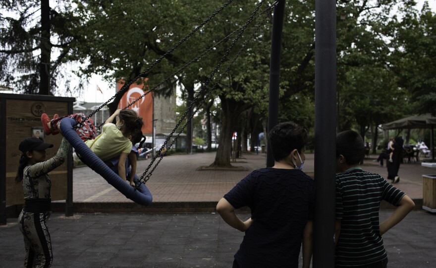 Children ride on a swing in Atapark, a park frequented by the Afghan community in Trabzon, Turkey.