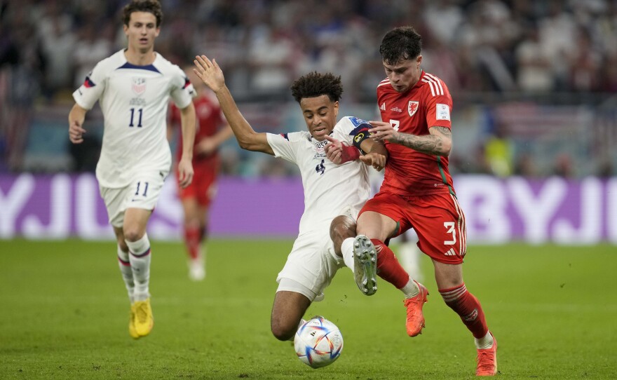Tyler Adams of the United States, and Wales' Ben Davies vie for the ball during the World Cup, group B soccer match between the United States and Wales, at the Ahmad Bin Ali Stadium in in Doha, Qatar, Monday, Nov. 21, 2022.