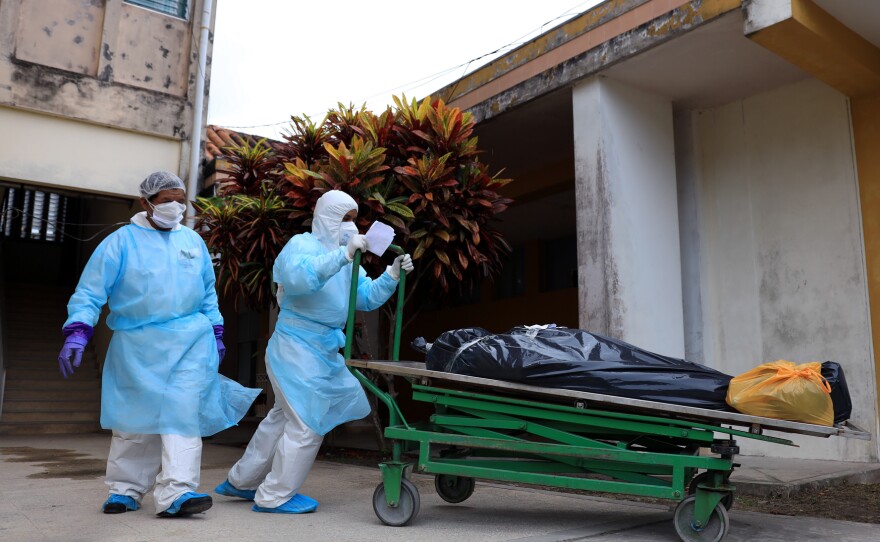 Health care workers take deceased COVID-19 victims to the morgue at Felipe Arriola Iglesias Hospital in Iquitos on May 4, 2020.