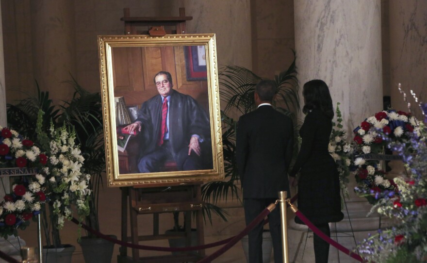 President Obama and first lady Michelle Obama look at a portrait of U.S. Supreme Court Justice Antonin Scalia after paying their respects in the Great Hall of the Supreme Court in Washington, D.C.
