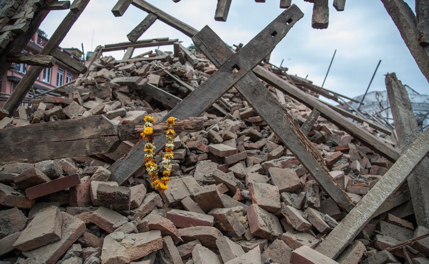 Flowers are left by survivors on top of debris from a collapsed building at Basantapur Durbar Square following the earthquake.