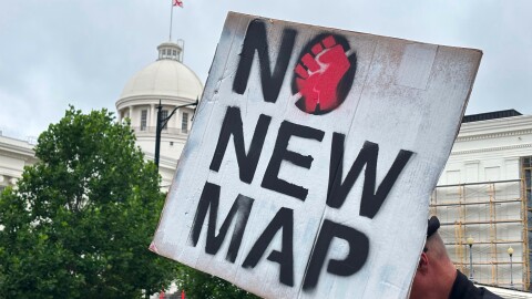 A demonstrator holds up a sign outside the Alabama Statehouse in Montgomery on Thursday.