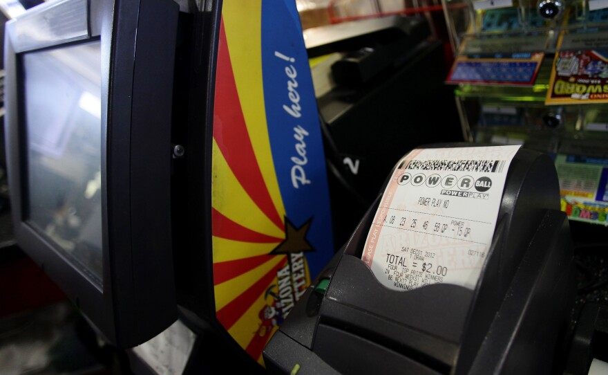 A Powerball lottery ticket sits in the machine at the 4 Sons Food Store and Chevron gas station which sold one of two winning Powerball lottery tickets in Fountain Hills, Ariz.