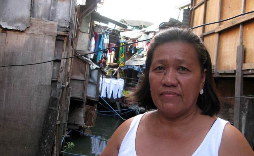Community organizer Filomena Cinco stands amid shacks on the Estero de San Miguel, a slum neighborhood in Manila. Residents want to redevelop their neighborhood, rather than be relocated to distant suburbs under a government plan.