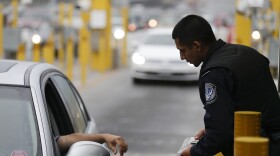 A Customs and Border Protection officer speaks to a driver in his lane at the San Ysidro Port of Entry, June 27, 2013.