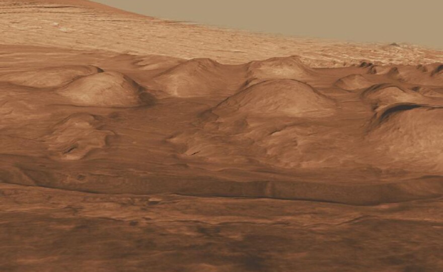 This oblique view of the lower mound in Gale crater shows layers of rock that preserve a record of environments on Mars. Here, orbiting instruments have detected signatures of both clay minerals and sulfate salts, with more clay minerals apparent in the foreground of this image and fewer in higher layers. This change in mineralogy may reflect a change in the ancient environment in Gale Crater. 