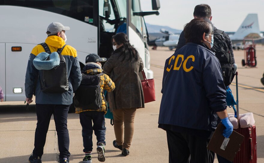 This Wednesday, Feb. 5, 2020 photo provided by The U.S. Department of Health and Human Services shows evacuees from China arriving at Marine Corps Air Station in Miramar, Calif.