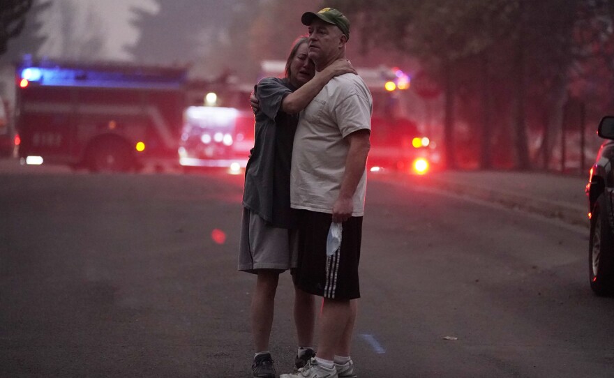 A couple embrace on Thursday while touring an area devastated by the Almeda Fire in Phoenix, Ore.