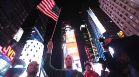 New Yorker Frank Franchi (C) waves an American flag as people celebrate in Times Square after the death of accused 9-11 mastermind Osama bin Laden was announced by U.S. President Barack Obama May 2, 2011 in New York City. 