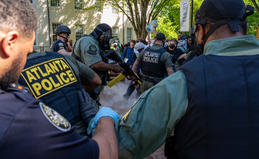 An Atlanta Police officer fires pepper pellets onto the ground as Atlanta Police Department and Georgia State Patrol order Pro-Palestinian and "Cop City" protesters to disperse from the quad on Emory University campus on Thursday, April 25, 2024.
