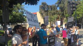 Members of Showing Up for Racial Justice San Diego hold up signs during a protest outside San Diego Police Department headquarters, July 21, 2016. 