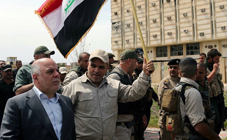 Iraqi Prime Minister Haider al-Abadi (left) tours Tikrit after it was retaken by security forces who drove out Islamic State fighters on April 1. Shiite militias allied with Iraqi government troops were accused of committing human rights abuses as they helped retake the city.