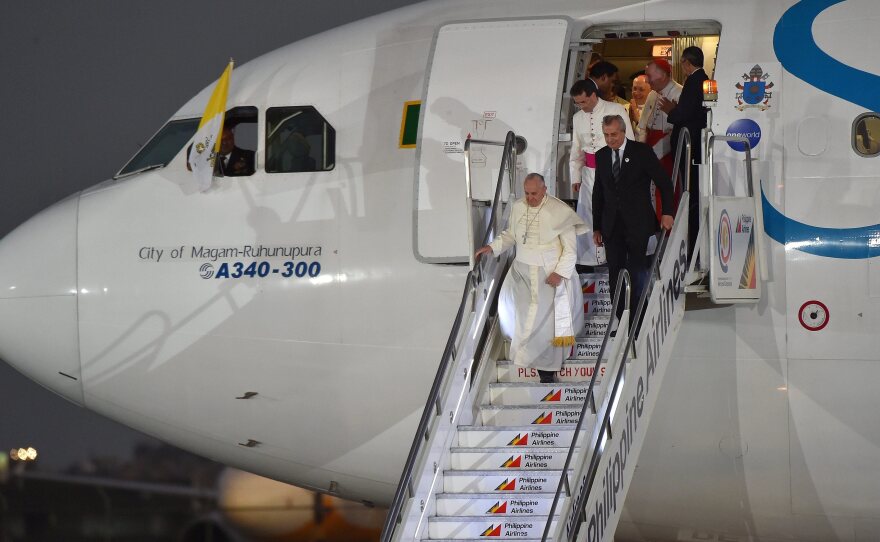 Pope Francis disembarks from the plane upon his arrival at the airport in Manila, Philippines, on Wednesday. In comments to reporters aboard the plane, Francis said though the attack on Charlie Hebdo magazine was an "aberration," free speech "cannot make provocations," especially against people's faith.