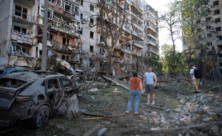 People look at a residential building damaged during the Russian missile attack in Kyiv, Ukraine, Thursday.