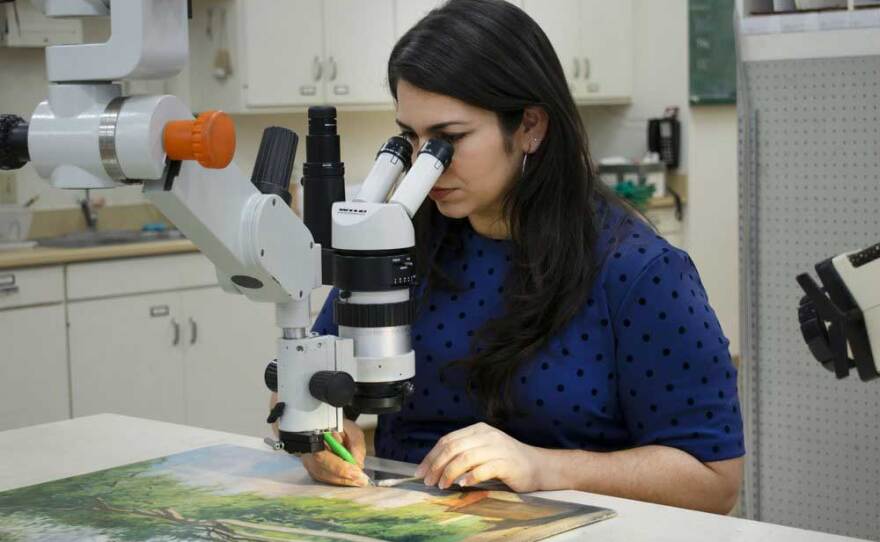 Bianca Garcia, conservator at Balboa Art Conservation Center works on a painting in an undated photo.