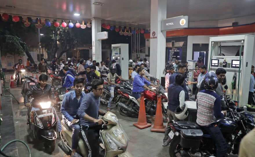 Indians crowd a gas station, one of the few places still accepting the high denomination 1,000 and 500 currency notes, in New Delhi.