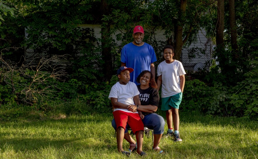 Jeneyah McDonald, her husband Earl and their children Josiah, 8, and Justice, 12, sit together in their yard outside of their home.