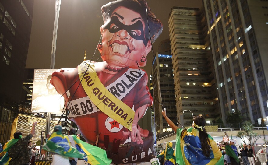Protesters parade an inflatable doll of Brazil's President Dilma Rousseff in Sao Paulo on Wednesday night, shortly before Congress voted to suspend her. The sashes say "Goodbye Dear" and "Mother of Big Oil." Rousseff, the president since 2010, now faces an impeachment trial.
