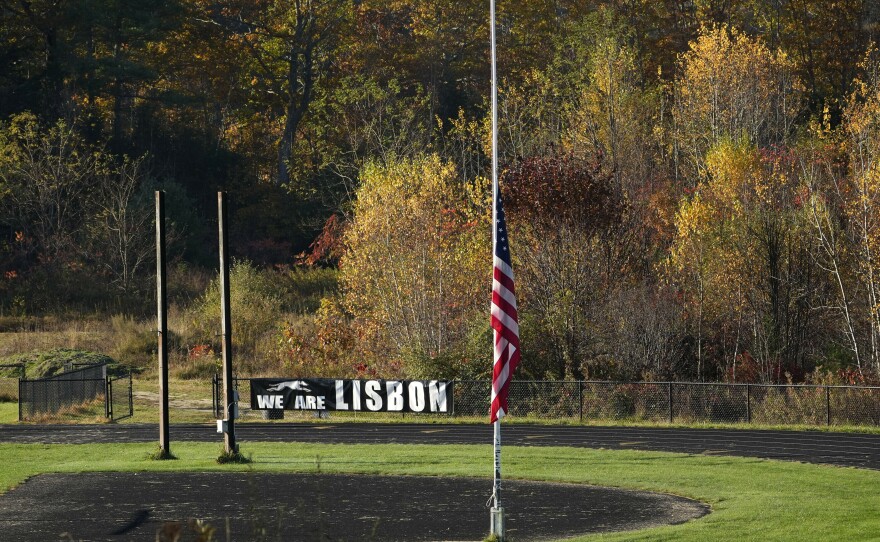 An American flag is set to half mast Saturday on a football field in Lisbon Falls, Maine, just a few hundred yards from a recycling facility where law enforcement found the body of Robert Card, the suspect in this week's mass shootings.