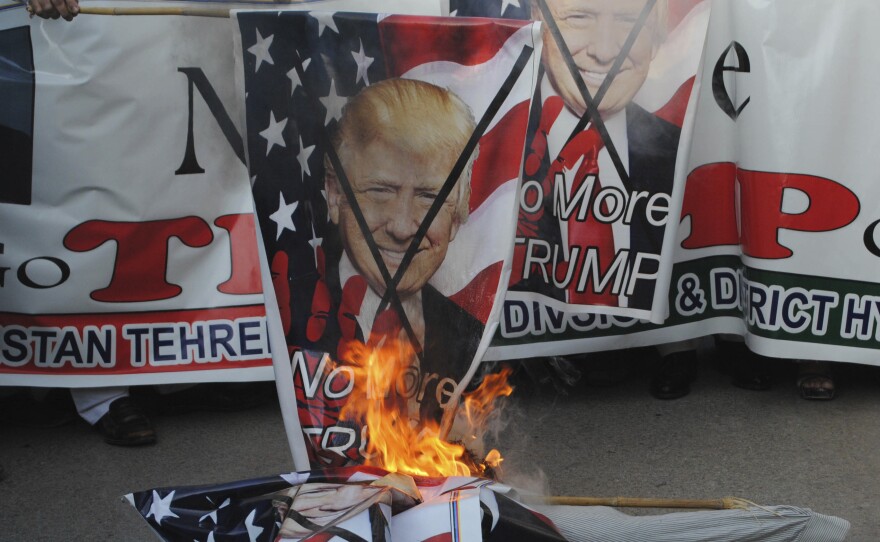 Protesters in Hyderabad, Pakistan, burn banners showing President Trump on Tuesday. Trump slammed Pakistan for "lies & deceit" in a New Year's Day tweet that said Islamabad had played U.S. leaders for "fools."