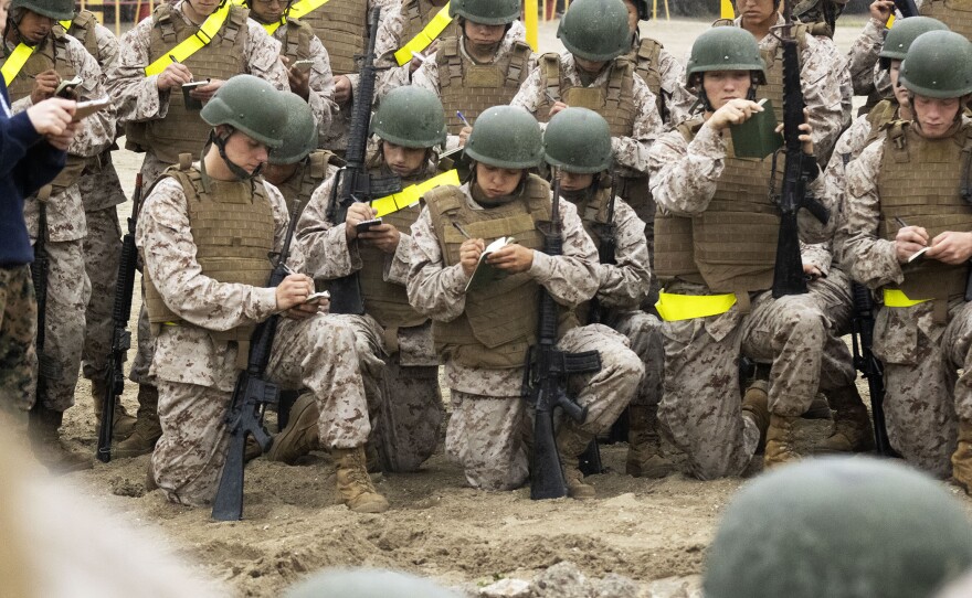 Lima Company Marine recruits taking notes during a simulated mission briefing at Marine Corps Recruit Depot, San Diego before starting on the Bayonet Assault Course, March 23, 2021.