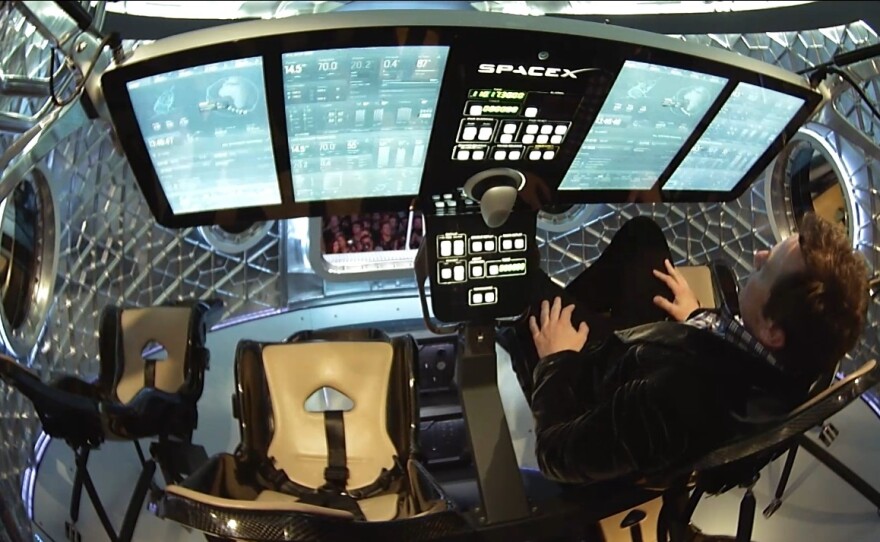 SpaceX founder Elon Musk briefly climbed inside the capsule to show off its flat panel cockpit.