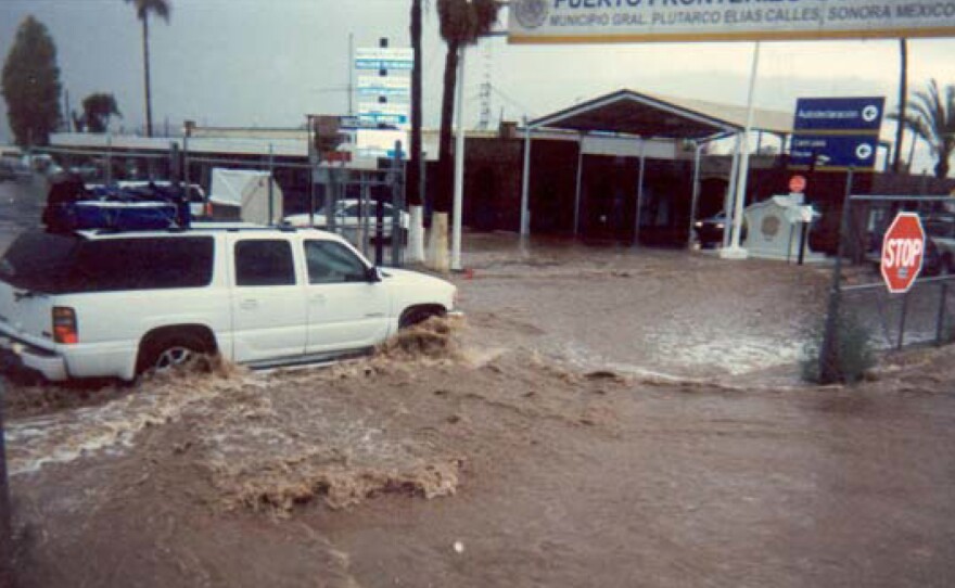 Blocked by the pedestrian fence, floodwaters from Headquarters Wash near Lukeville, Ariz., flowed along the fence and into the Mexican Port of Entry in Sonoyta, Sonora, in 2008.
