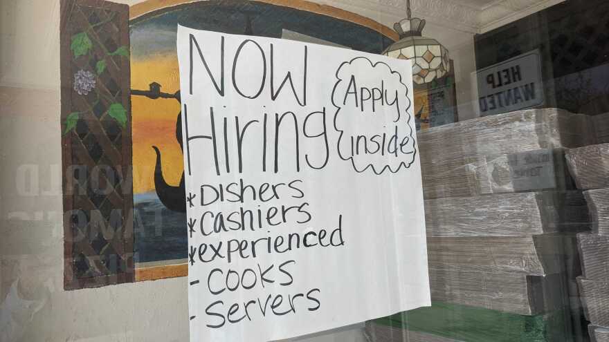 A "now hiring" sign hangs in the window of Filipe's Pizza in Escondido, Calif. Aug. 9, 2021.